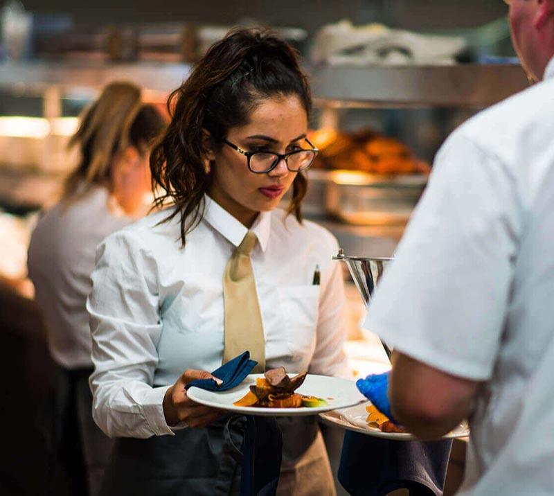 Waiting staff undertake a final Quality Assurance check before taking the food out to diners.