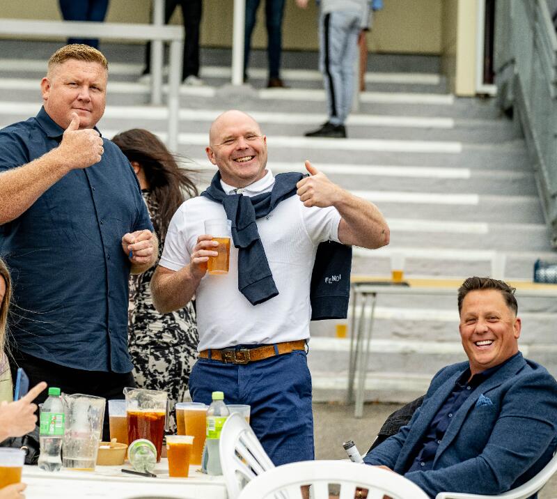 Three gents enjoying a drink at Lingfield races.