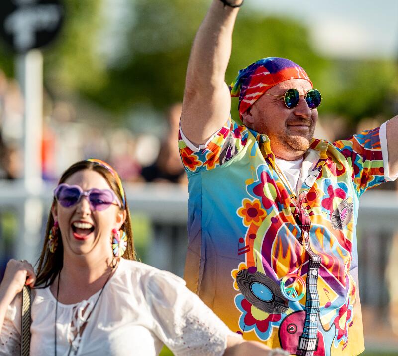 A couple in themed outfits at Lingfield Park smile and laugh