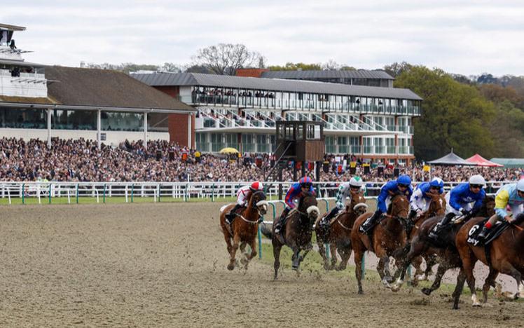 Group of jockeys racing around a corner on a track.