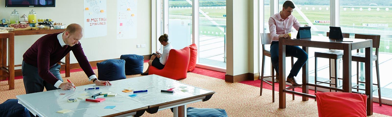 A workspace with three office people working in different mediums.