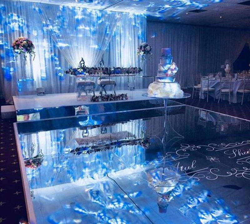 Room dressed up for an asian wedding, with the wedding cake standing in the middle of the room.