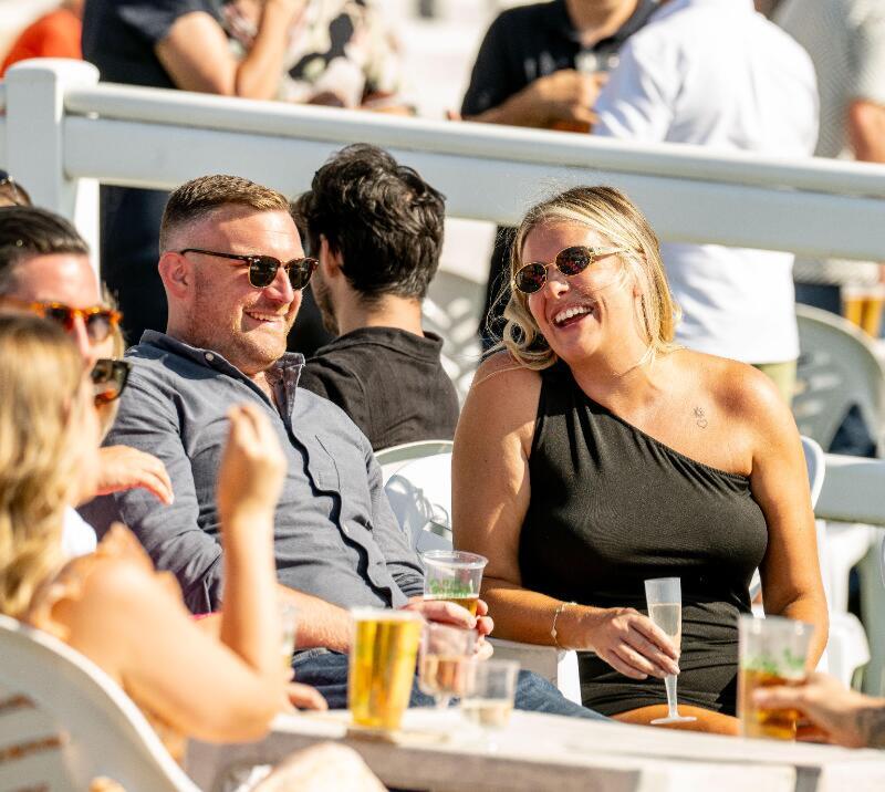 A couple looking smiley and carefree at Lingfield Races