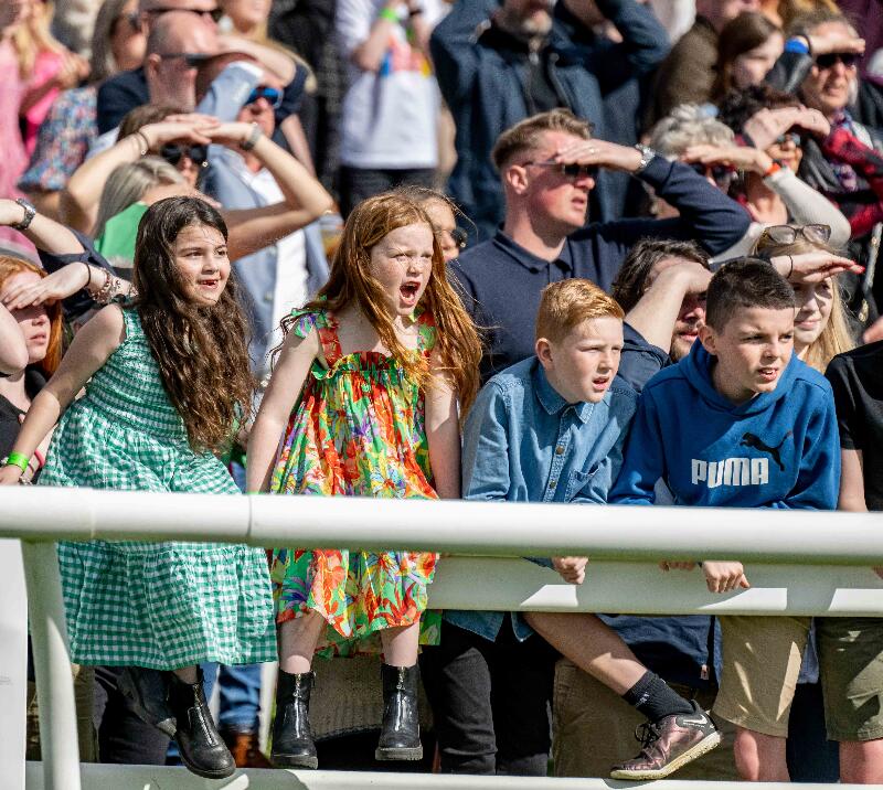 Young racegoers cheering at the races.